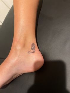 a person with a tattoo on their foot that has a cowboy boot in the middle