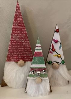 three small christmas trees are sitting on a shelf