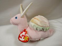 a pink stuffed animal with white horns on it's back and a candy bar in its mouth