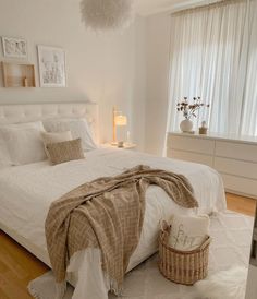 a bedroom with white walls and wooden floors