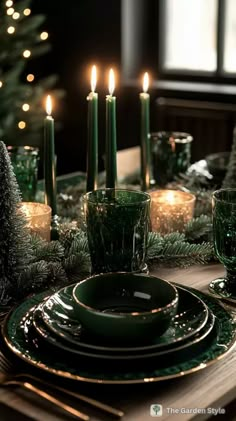 a christmas table setting with candles and green dishes