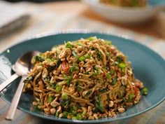 a blue plate topped with noodles and veggies