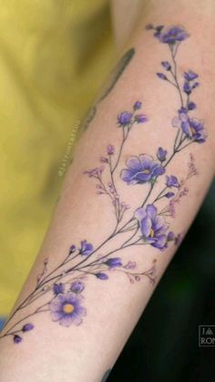 a woman's arm with purple flowers on it