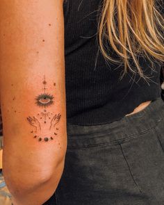 a woman's arm with an all seeing tattoo on it