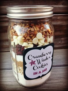 a jar filled with cookies and nuts on top of a wooden table next to a sign