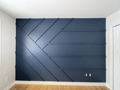 an empty room with blue walls and wood floors