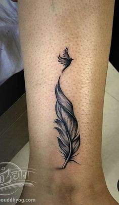 a black and white feather tattoo on the ankle