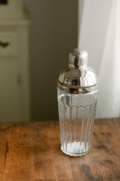 an empty glass bottle sitting on top of a wooden table