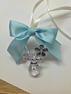 a close up of a brooch on a piece of paper with a ribbon around it