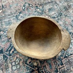 a wooden bowl sitting on top of a rug