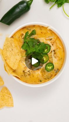 a white bowl filled with tortilla chips and green peppers