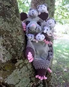 a group of stuffed animals hanging from the side of a tree