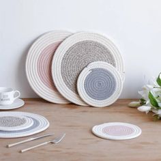 three woven placemats and two plates on a table with flowers in the background