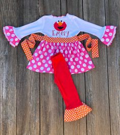 a pink and white polka dot dress with red leggings on a wooden floor