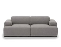 a grey couch with two pillows on it's back and one arm facing the camera