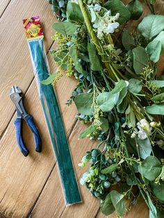 the tools are laying on the table next to the flowers and greenery laid out