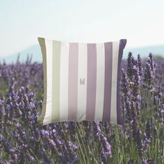 a striped pillow sitting on top of a lavender field