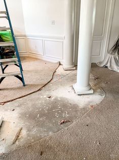 a room with a ladder and some paint on the floor next to a wall that has been stripped off