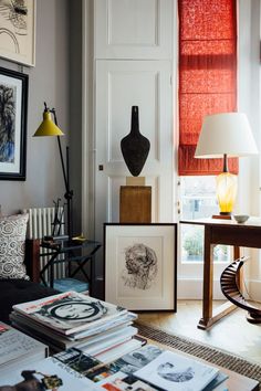 a living room filled with lots of furniture and pictures on the wall next to a lamp