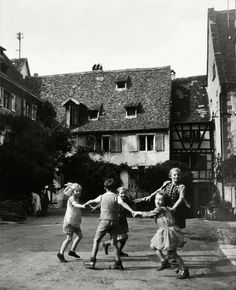 four children are playing with each other in the street