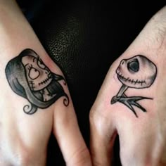 two people with matching tattoos on their hands, one has a skull and the other is a snake