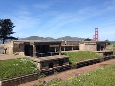 an old building with grass growing on the roof and in front of a golden gate