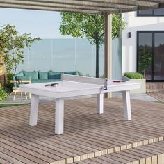 a white ping pong table sitting on top of a hard wood floored patio