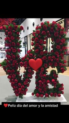 the letter r is made out of roses and has a red heart in front of it