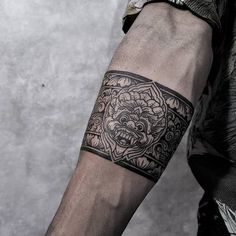 a man's arm with a tattoo on it that has a dragon in the center