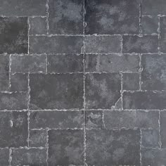 an image of a black brick wall textured with grey paint and grouting