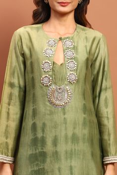 Olive green tie-dyed georgette Pakistani style kurta with keyhole neck, sequin, bead, cut dana hand embroidered yoke and sleeve borders. Paired with pant and chita embroidered dupatta.
Components: 3
Pattern: Hand Embroidered and Printed
Type Of Work: Sequin, Bead, Cut Dana and Chita Work
Neckline: Keyhole Round Neck
Sleeve Type: Three Quarter Sleeves
Fabric: Georgette
Color: Green
Other Details: 
Embroidered pant border
Side slits on kurta
Tasselled dupatta border
Kurta Closure: Front loop butto Printed Georgette Suit Designs, Dupatta Border, Pakistani Style, Kurta Set For Women, Fabric Paint Designs, Diwali Craft, Embroidered Pants, Suits Design, Keyhole Neck