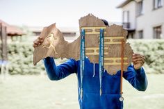 a person holding up a piece of wood with the shape of a bird on it