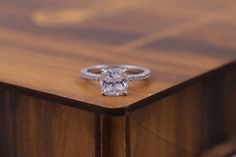 a diamond ring sitting on top of a wooden table