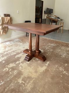 a large wooden table sitting on top of a carpeted floor next to a wall