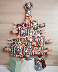 a group of people standing around a christmas tree