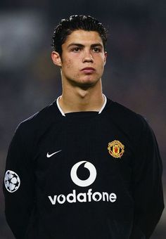 the young man is wearing a black shirt and standing in front of a soccer ball