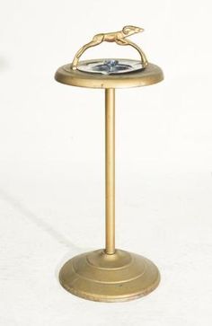 a small brass table with a bird on it's top and a water fountain in the middle