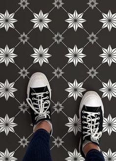 a person standing on top of a black and white tile floor with stars in the background