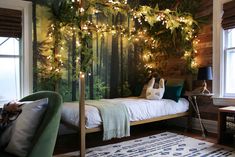 a bedroom decorated for christmas with lights and greenery on the wall above the bed