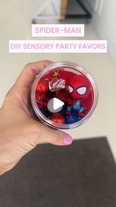 a hand holding a plastic container filled with spider - man ornament ornaments and text that reads, spider - man diy party favors