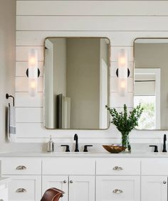 a bathroom with two sinks and mirrors on the wall