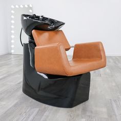 a brown chair sitting on top of a hard wood floor next to a black bag