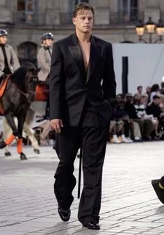 a man in a tuxedo walks down the runway