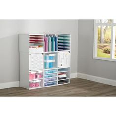 a white bookcase filled with lots of different types of paper and crafting supplies