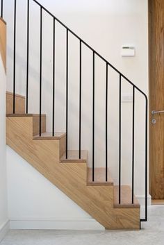 a wooden stair case with metal handrails in a home entryway, leading up to the second floor