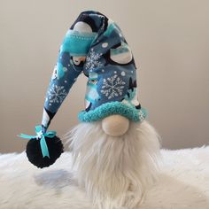 a stuffed animal wearing a blue and white hat with snowflakes on it's head