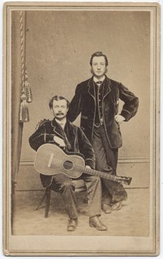 an old photo of two men with guitars