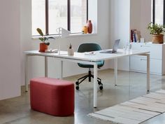 an office with a desk, chair, and ottoman in the middle of the room