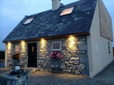 a small stone house with lights on the windows