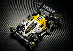 a yellow and white race car on a black background with the words rc racing circle above it